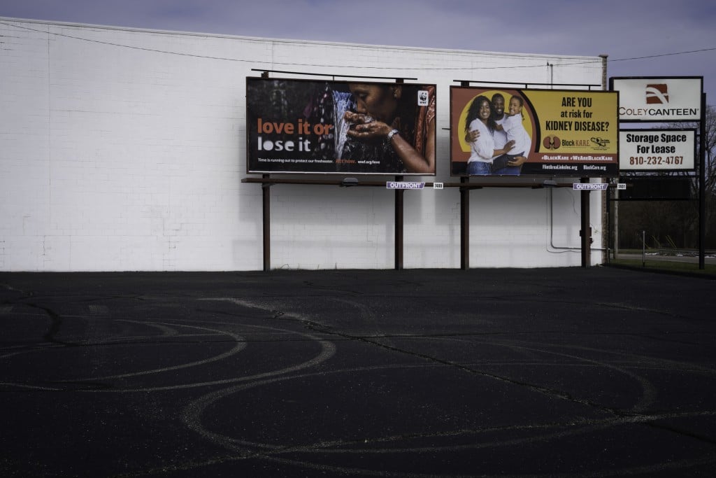Billboards against a white building in an empty parking lot