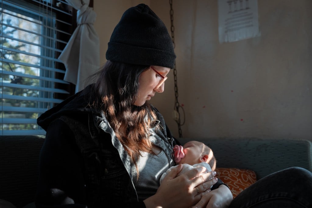 A woman holds a small baby