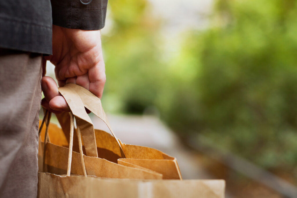 Hand holding paper grocery bags