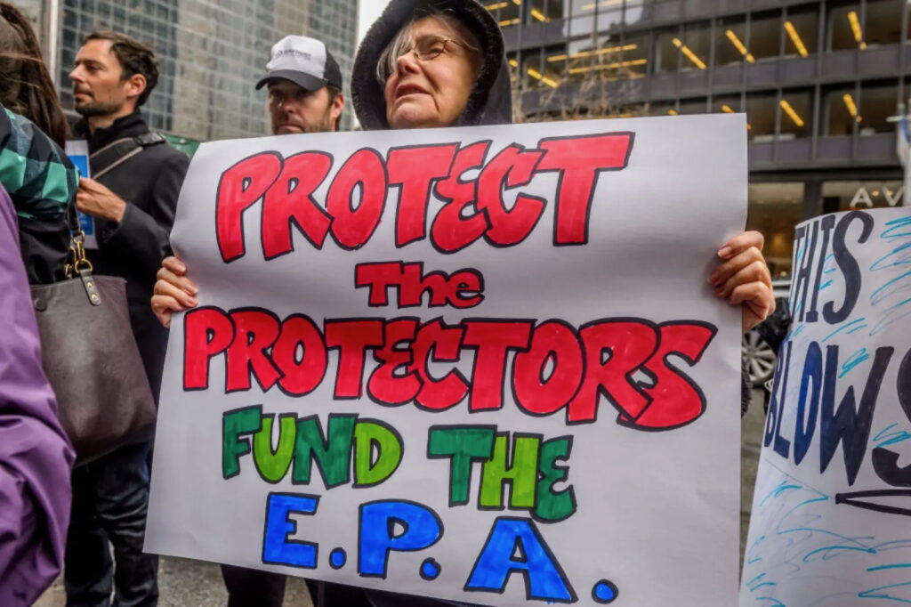 Protester holds sign that reads: "Protect The Protectors. Fund The E.P.A."