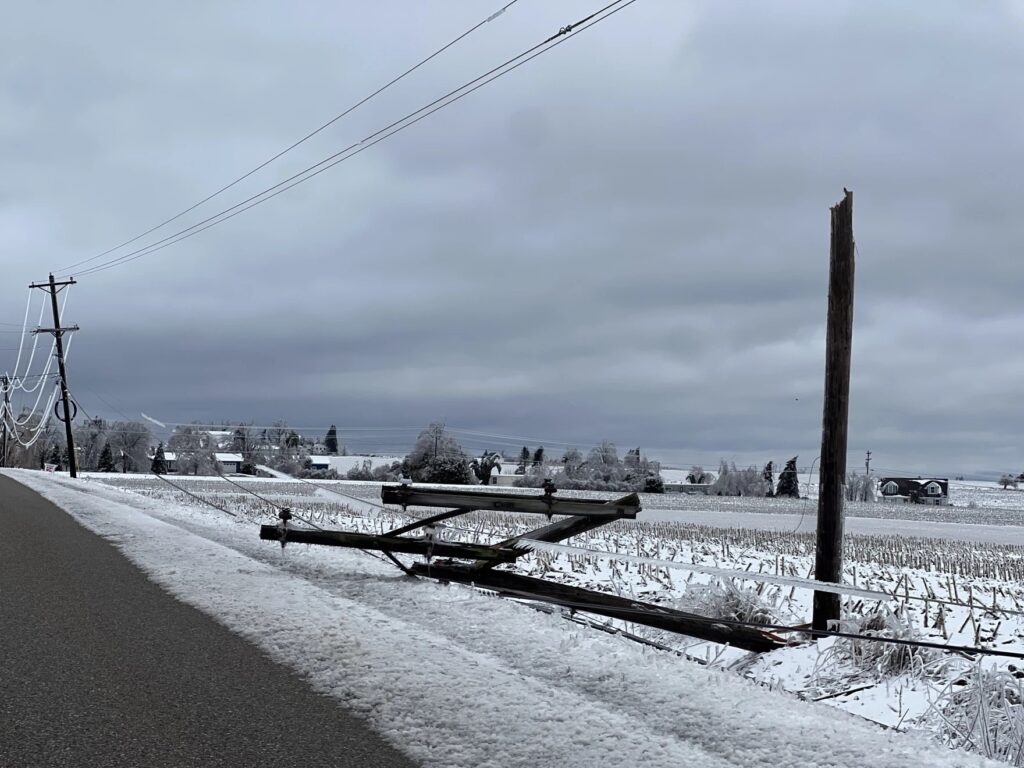 A snapped-off utility pole lays by the side of the road in Bear Creek Township after an ice storm.