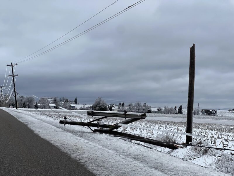 A snapped-off utility pole lays by the side of the road in Bear Creek Township after an ice storm.