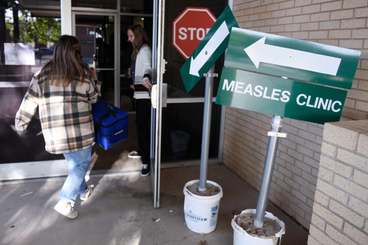 Health department workers enter facility in Andrews, Texas with doses of measles vaccine.