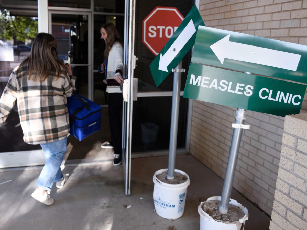 Health department workers enter facility in Andrews, Texas with doses of measles vaccine.