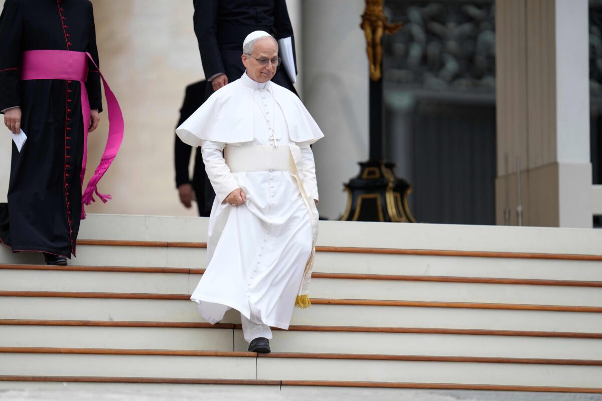 Pope Leo XIV walks down the stairs at the Vatican.