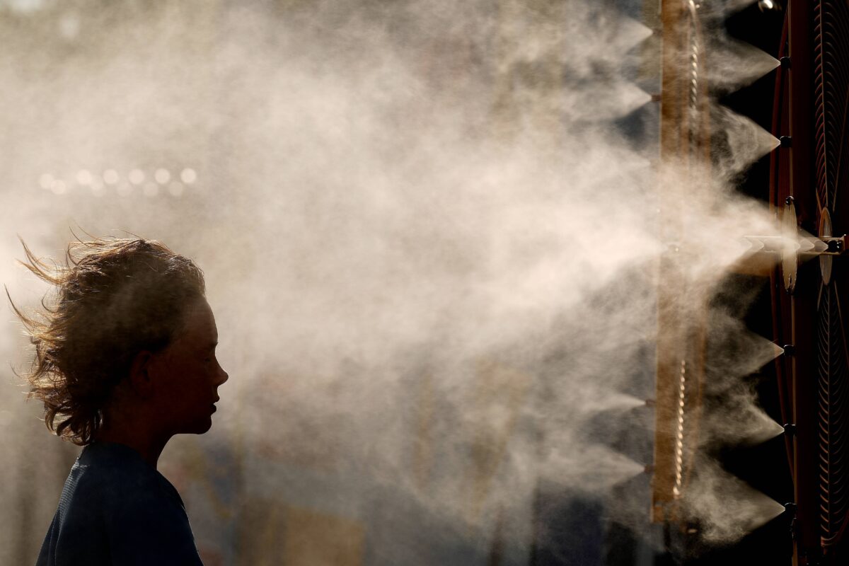 A child cools off in a mister before a baseball game in Kansas City, Missouri.