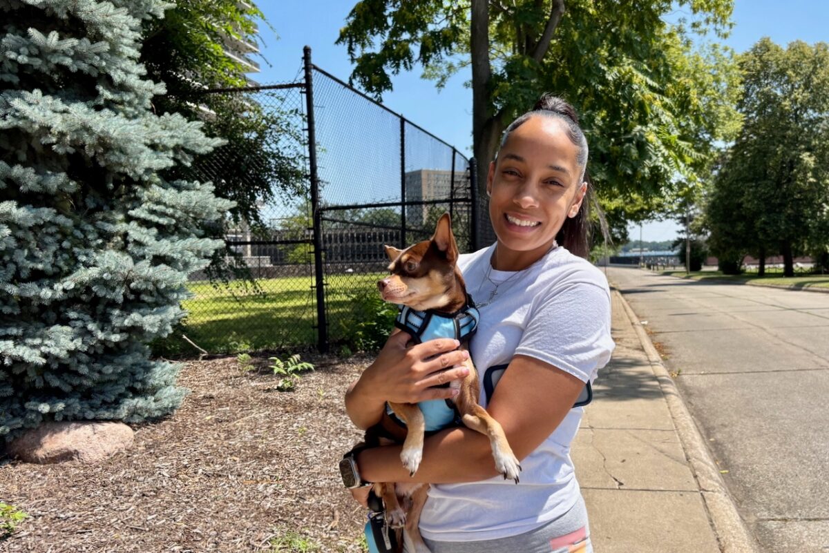 Kimberly Speight holds her dog in her arms outside the Jefferson Apartments in Detroit.
