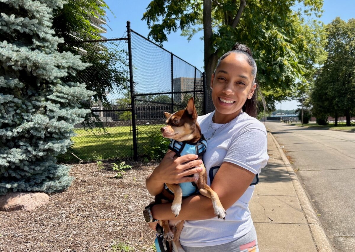 Kimberly Speight holds her dog in her arms outside the Jefferson Apartments in Detroit.