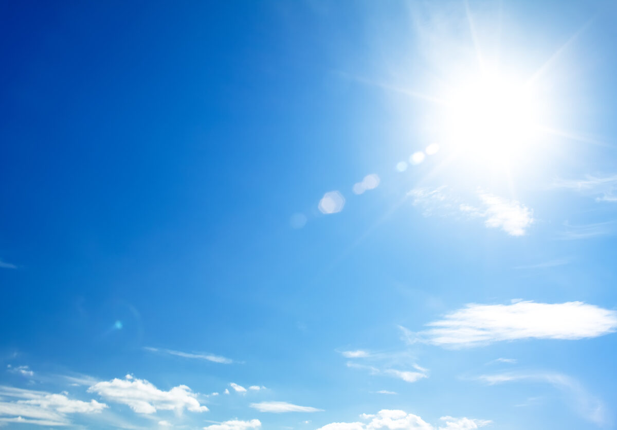 bright blue sky with the sun causing lens flare