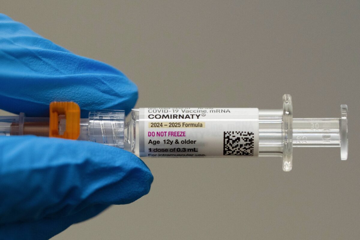 A pharmacist holds a Pfizer COVID vaccine