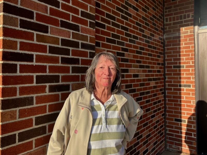 Augusta Township resident Dale-Lin Mallonen stands against a brick wall outside the municipal offices.