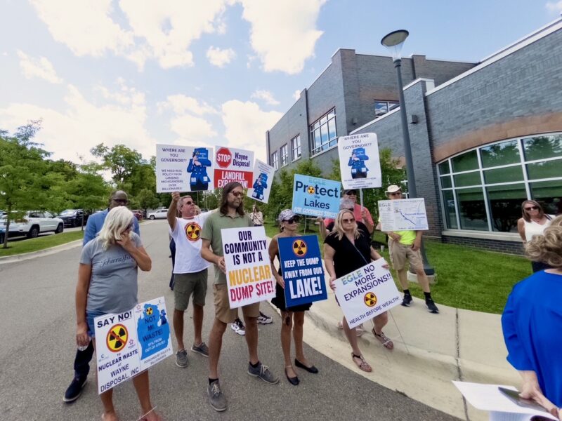 Protestors outside Belleville Area District Library hold signs such as "our community is not a nuclear dump site!"