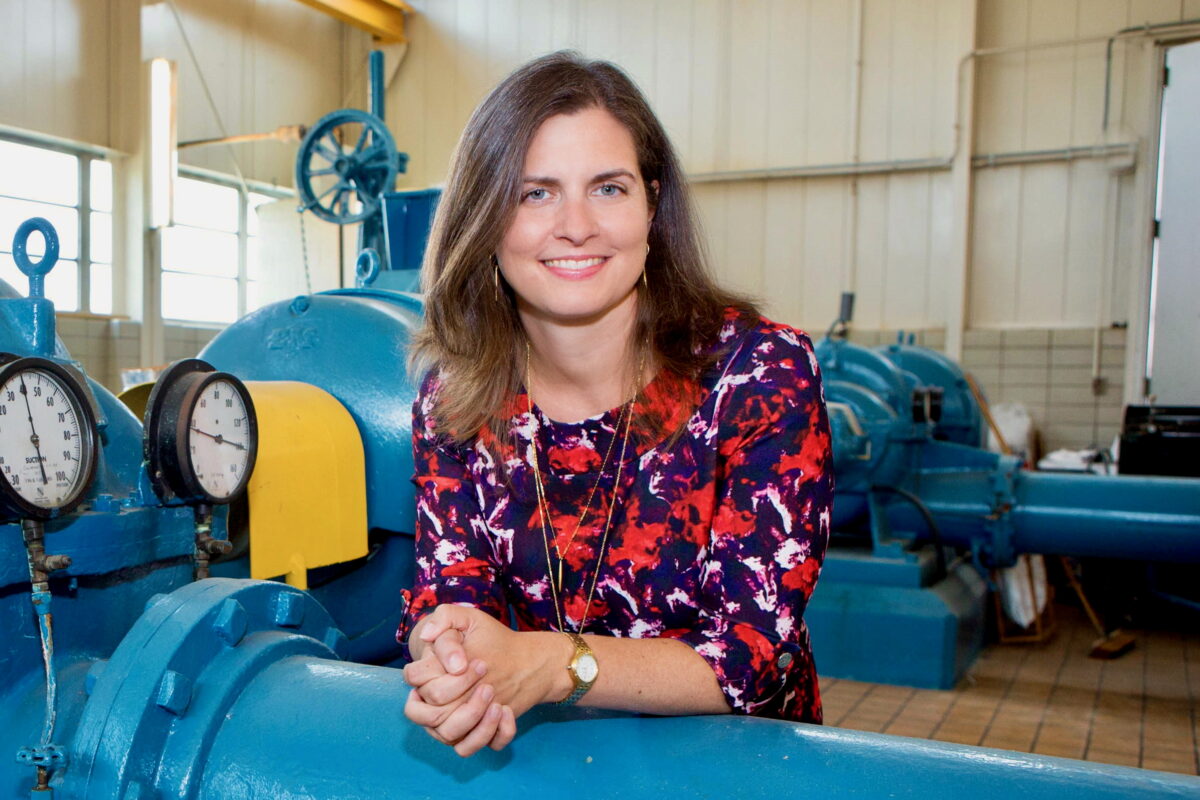 Drinking water expert Elin Betanzo leans on a blue drinking water pipe