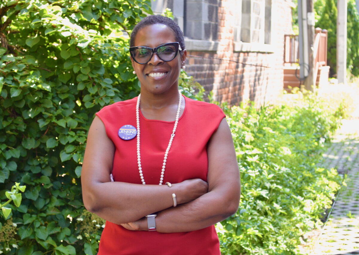 Detroit mayoral candidate Saunteel Jenkins, who is wearing a red shirt, stands with arms crossed.