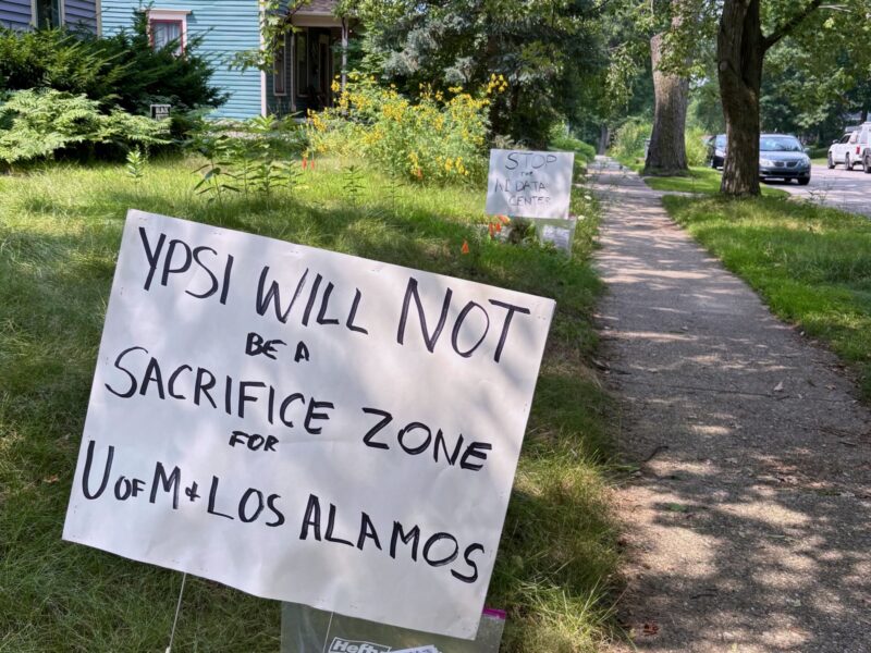 A yard sign in Ypsilanti reads "Ypsi will not be a sacrifice zone for U of M and Los Alamos."