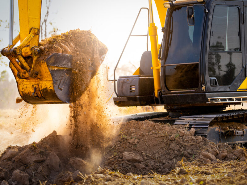 Backhoe moves dirt at construction site