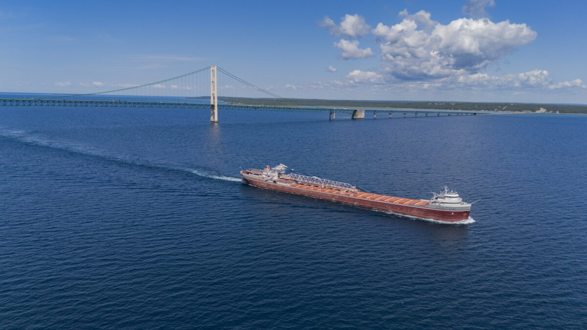 Red Great Lakes freighter passes the Mackinac Bridge.