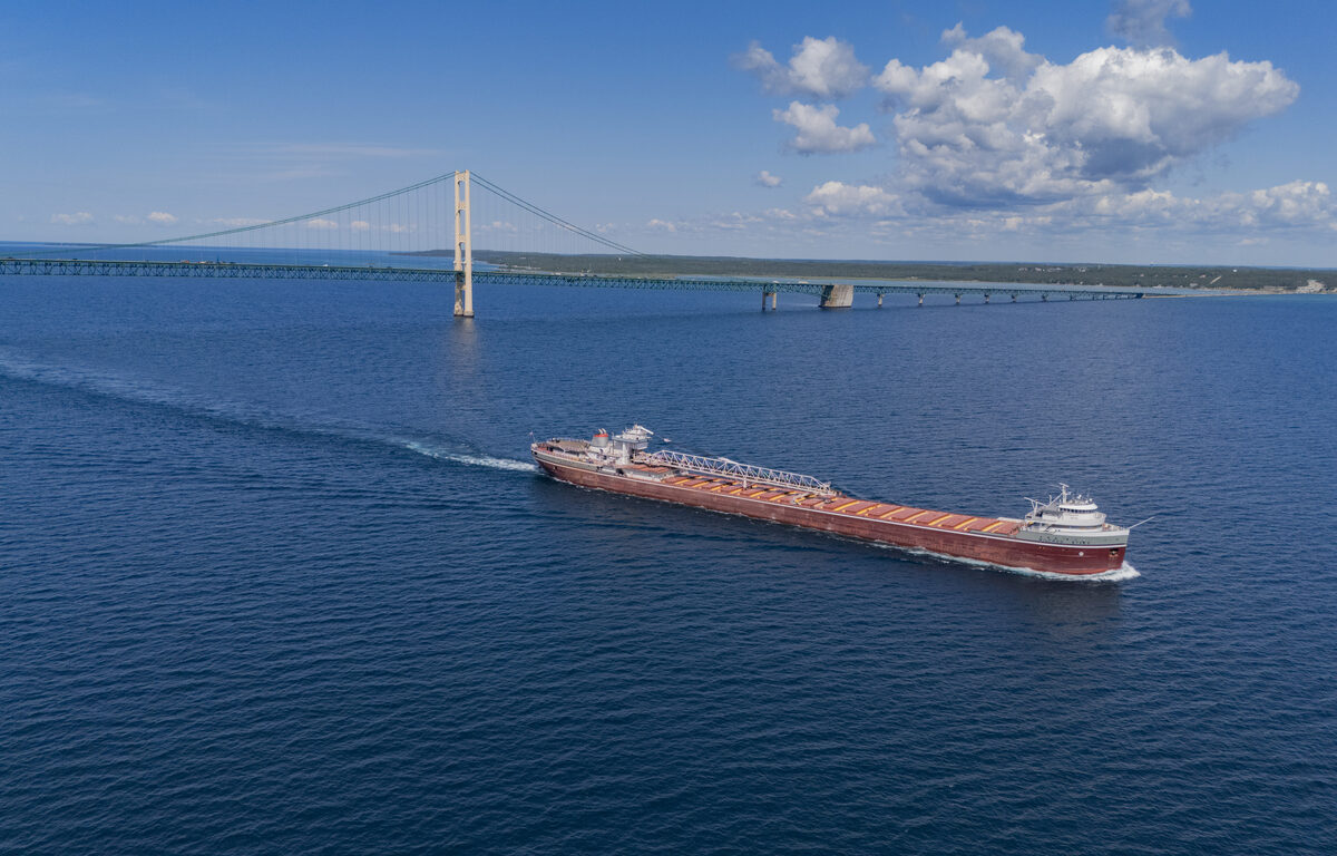 Red Great Lakes freighter passes the Mackinac Bridge.