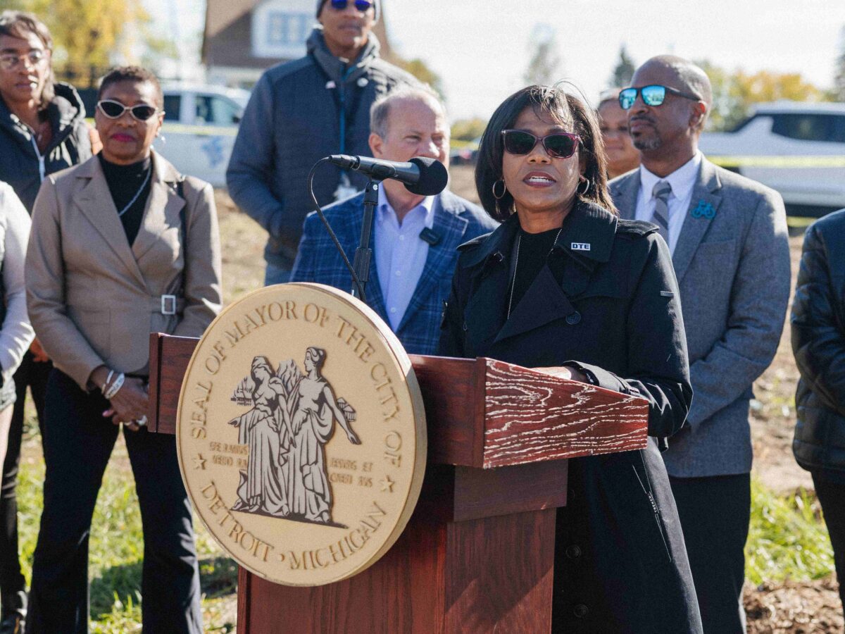 DTE Energy CEO Joi Harris speaks from a podium at a community solar groundbreaking on Detroit's east side.