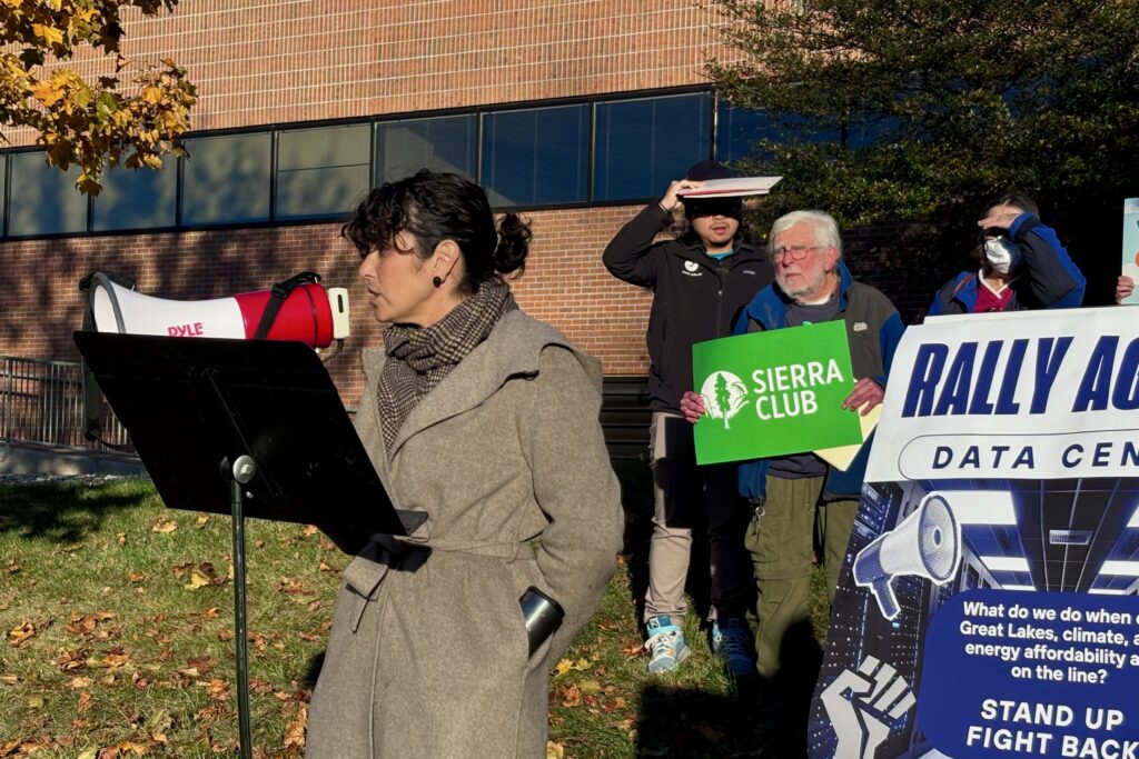 Michelle Martinez, director of the University of Michigan’s Tishman Center for Social Justice and the Environment, speaks into a bullhorn.
