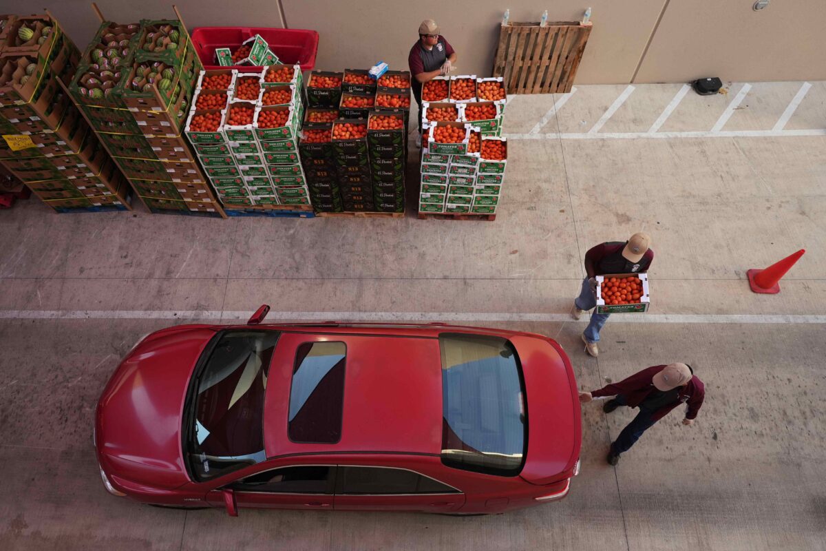 Volunteers help load vehicles during a food distribution at the San Antonio Food Bank for SNAP recipients and other households affected by the federal shutdown.