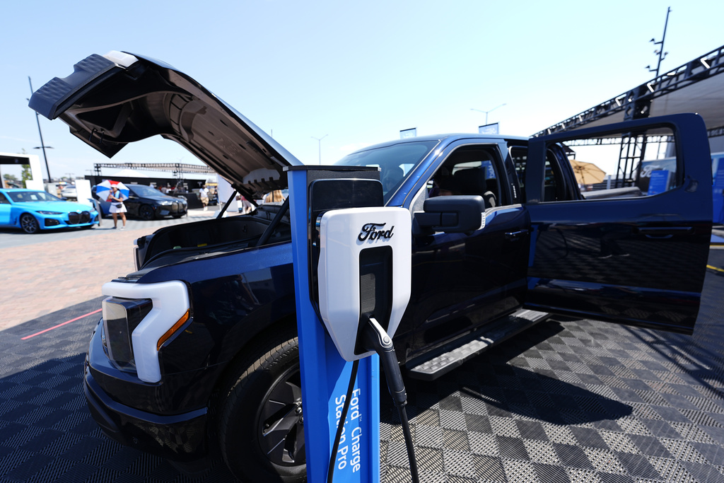 A charger stands next to a 2024 Ford F150 Lightning