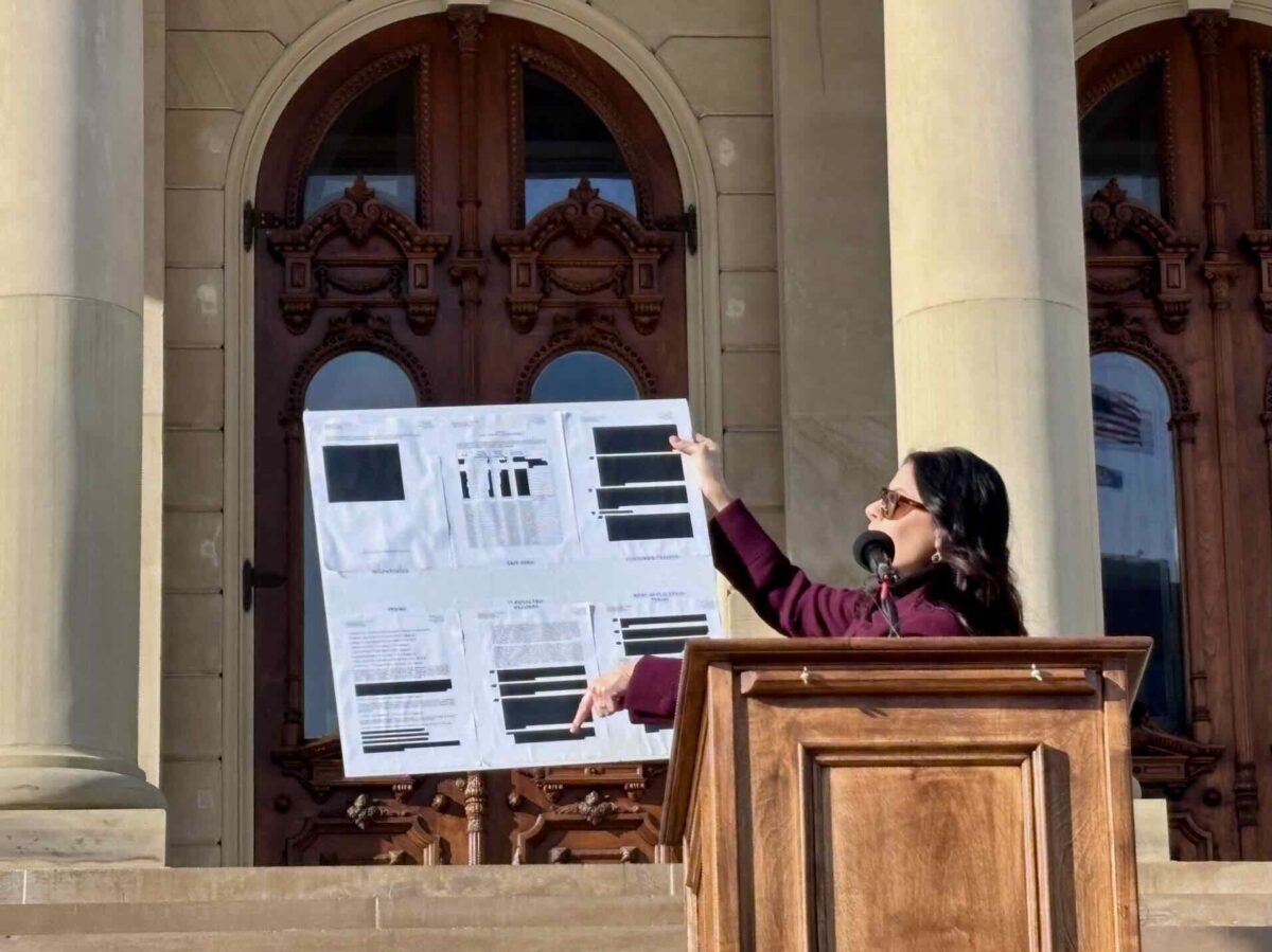 Michigan Attorney General Dana Nessel holds up redacted DTE Energy data center contracts at the state Capitol.