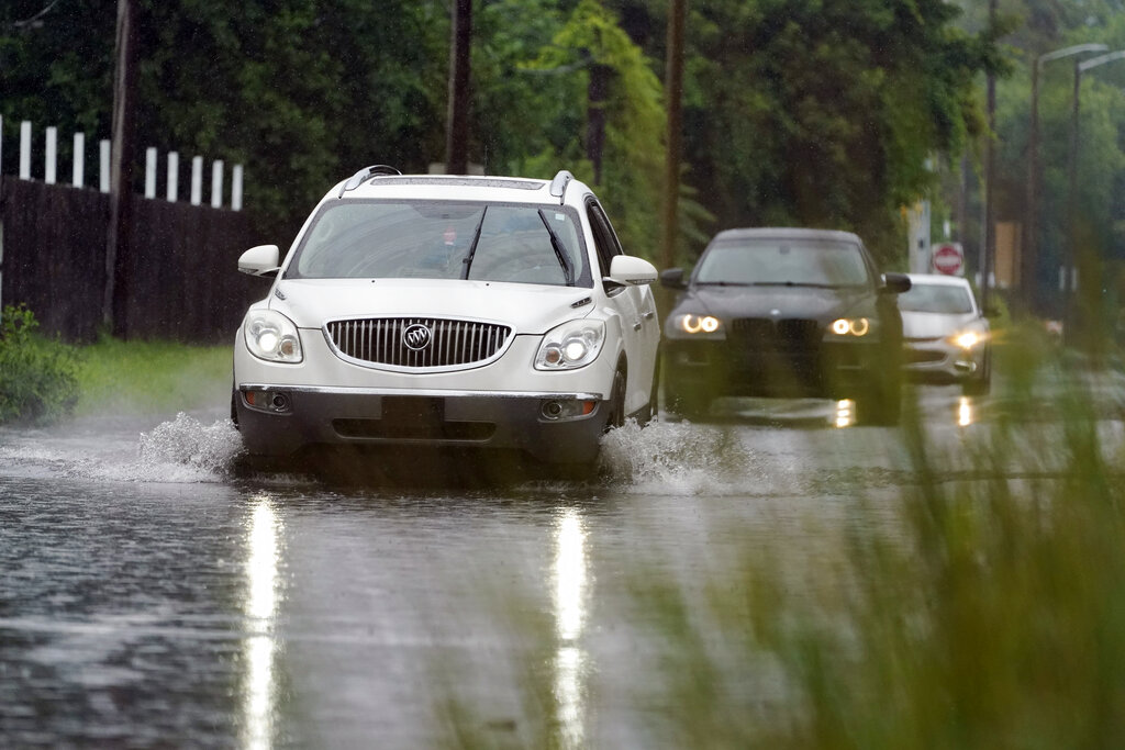 Cars drive through a flooded street, Friday, July 16, 2021, in Detroit.