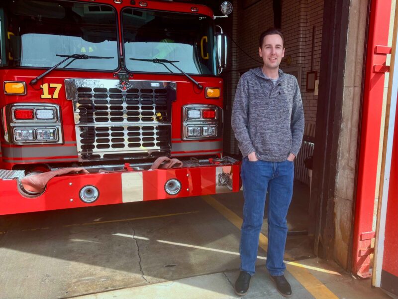 Planet Detroit managing editor Dustin Blitchok outside Detroit Fire Department Engine 17.