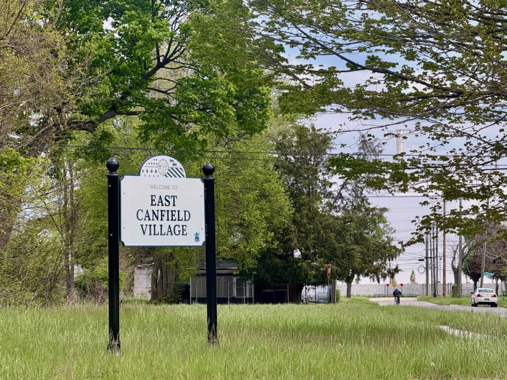 East Canfield Art Park sign with Stellantis plant in background.