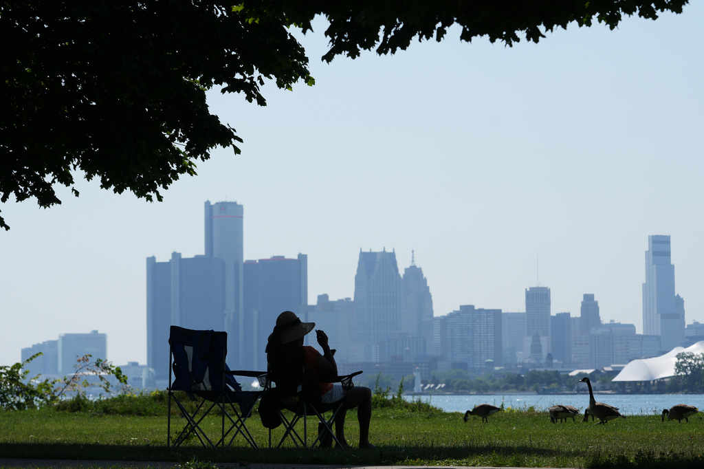 A woman sits in the shade to avoid the heat in Detroit.