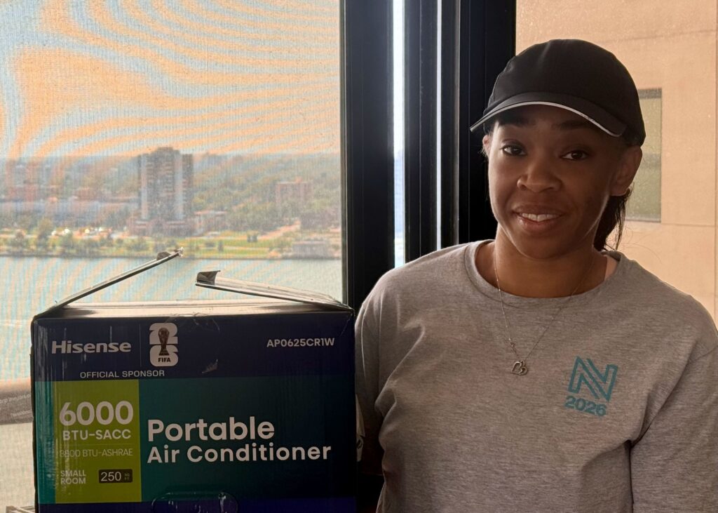 Riverfront Towers resident Erin McKaye holds a $350 portable air conditioning unit.
