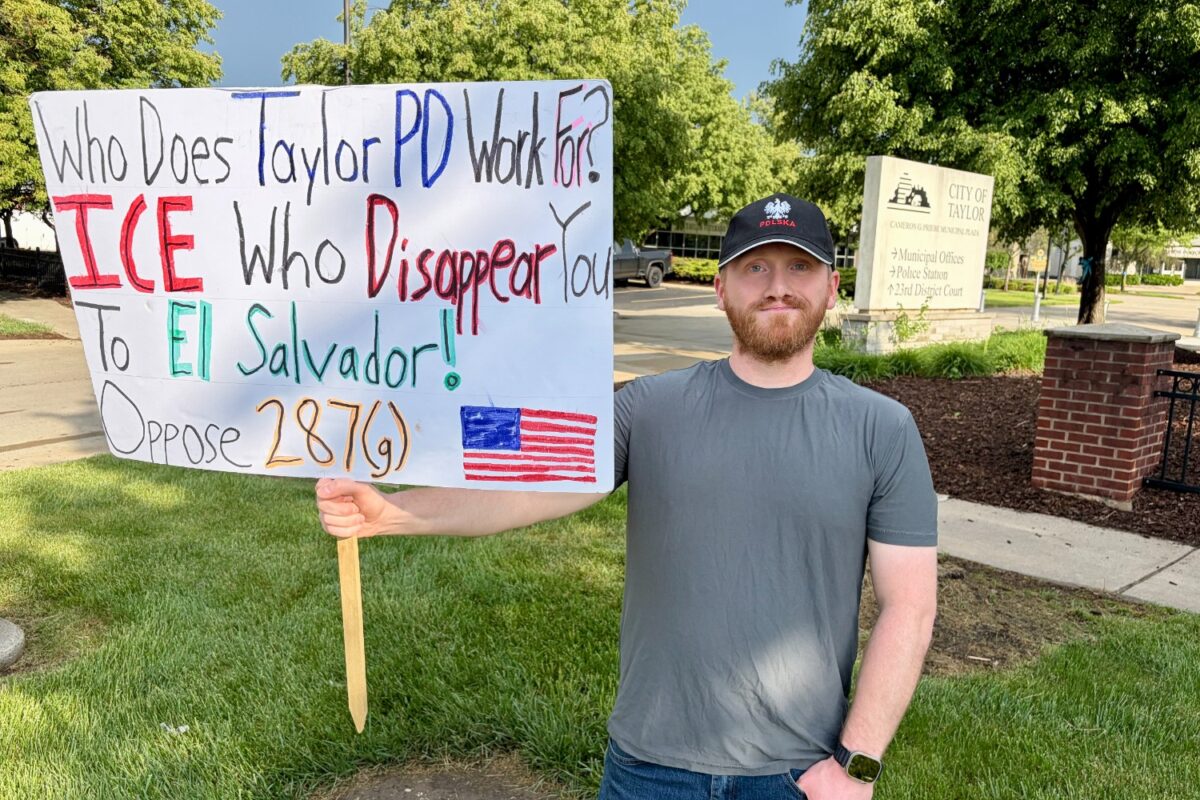 Taylor resident Tim Kachinski with a sign protesting the city's cooperation agreement with ICE.