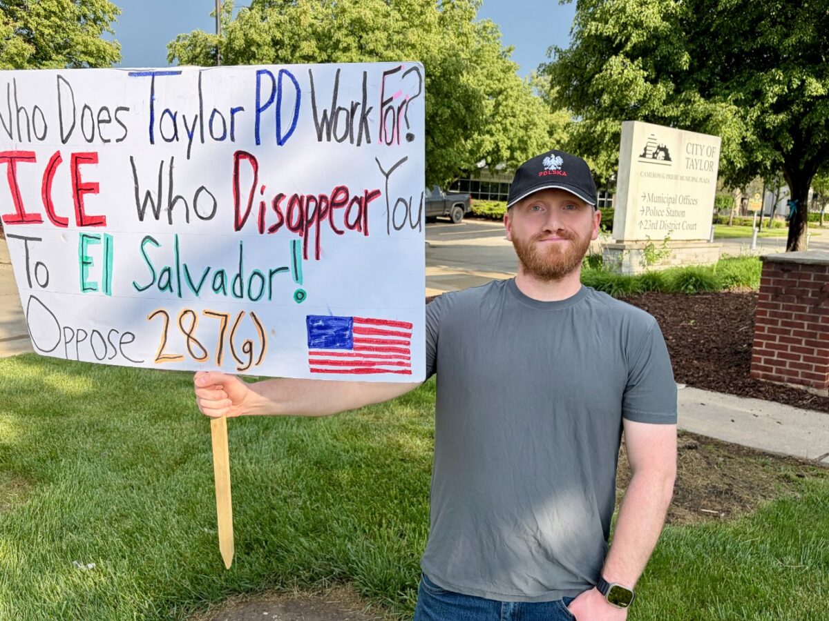 Taylor resident Tim Kachinski with a sign protesting the city's cooperation agreement with ICE.