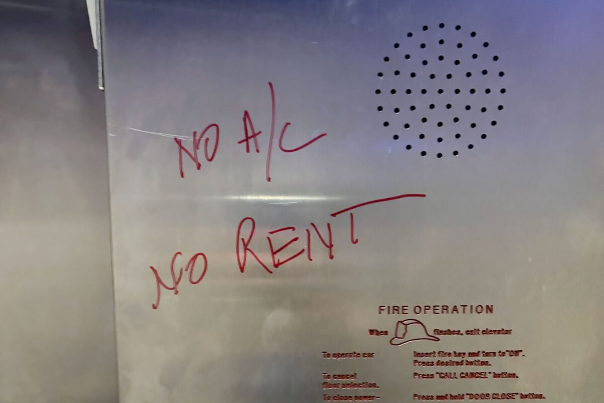 "No A/C, No Rent" is written in red on an elevator wall at Riverfront Towers in Detroit.