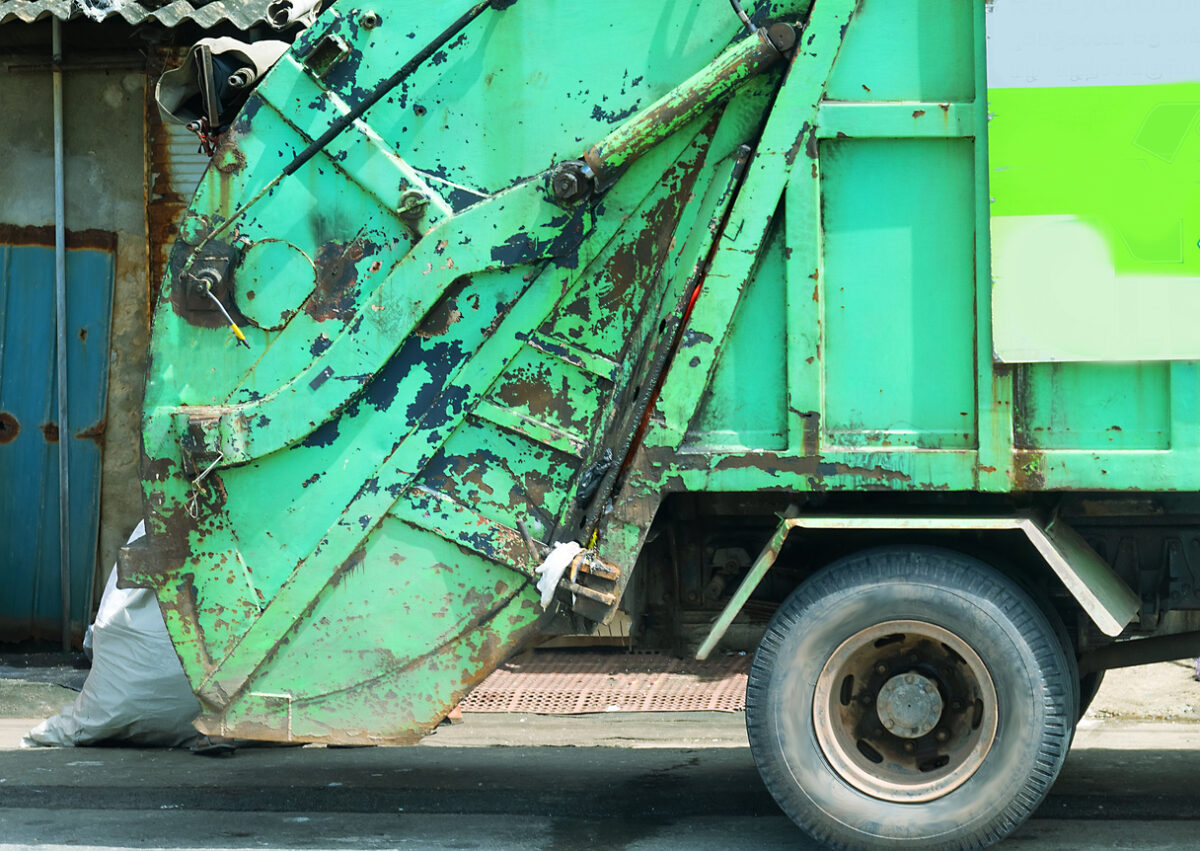 Green garbage truck side view