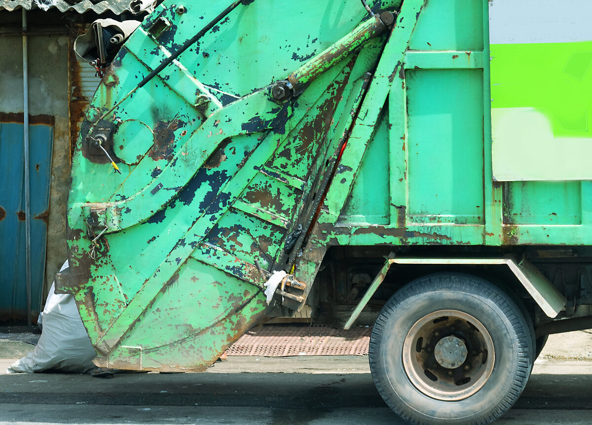 Green garbage truck side view